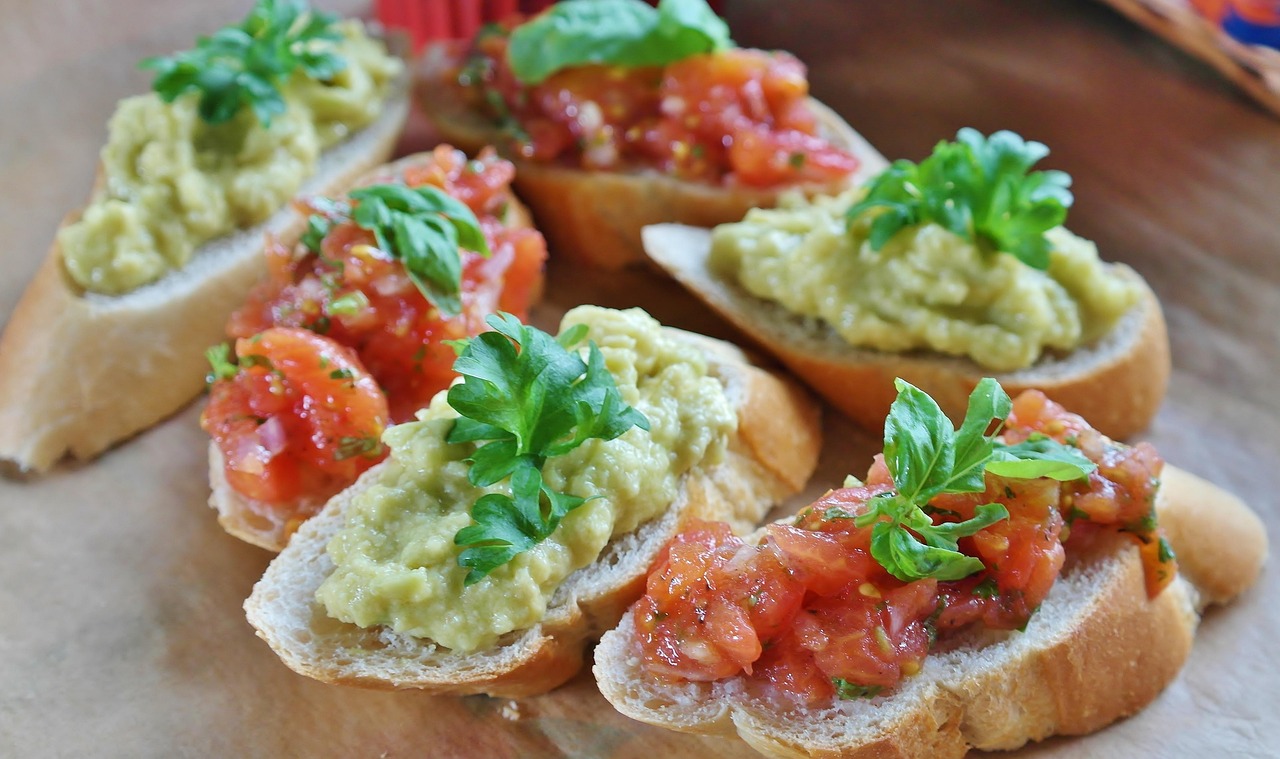 Bruschette con avocado su un tagliere, pronte per essere servite come antipasto veloce.
