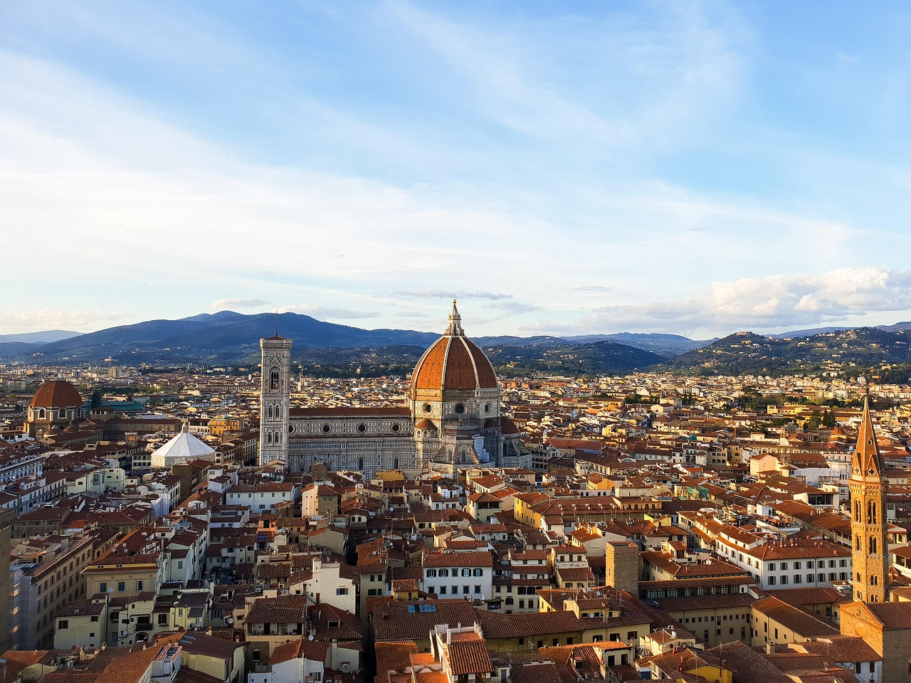 Panorama di Firenze in autunno, con alberi dai colori caldi e il Duomo sullo sfondo.