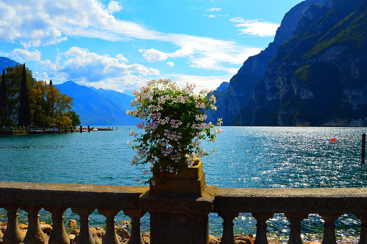 Panorama del Lago di Garda in autunno, con colori vivaci e turisti che esplorano la costa.
