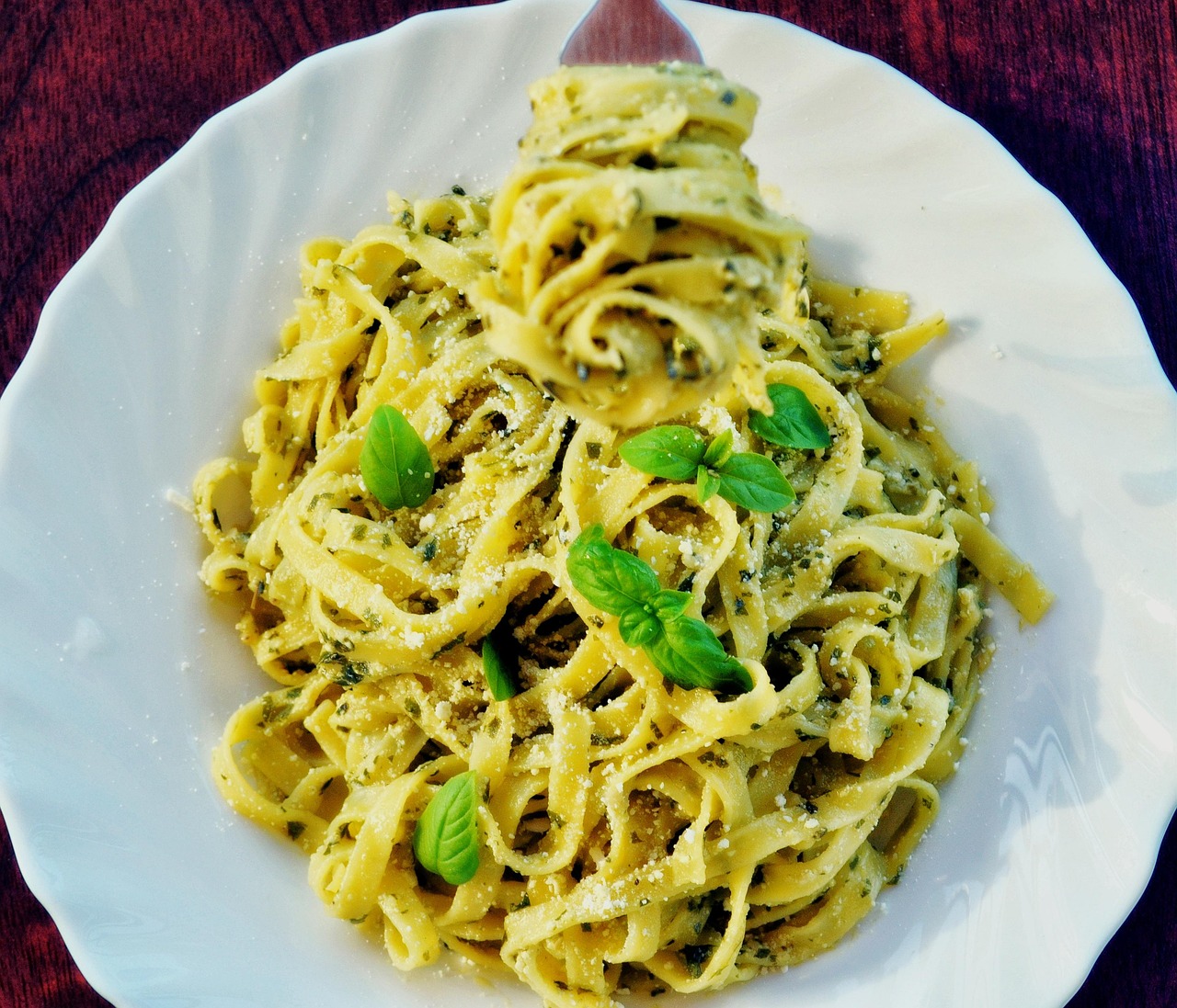 Pasta al pesto di basilico, con ingredienti freschi e profumati, servita in un piatto colorato.