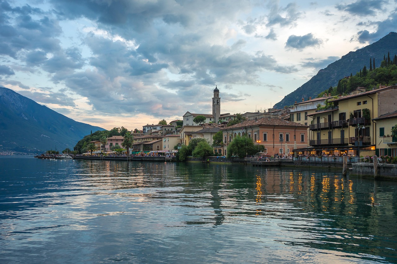 Panorama di un pittoresco borgo lacustre italiano immerso nella fioritura primaverile.