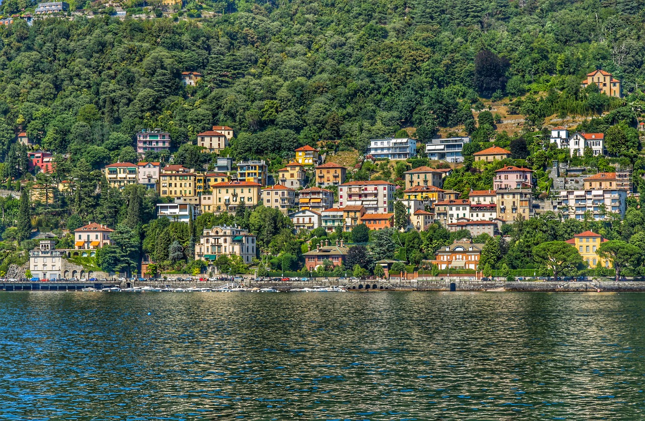 Vista panoramica sul lago di Como con borghi pittoreschi e montagne sullo sfondo.
