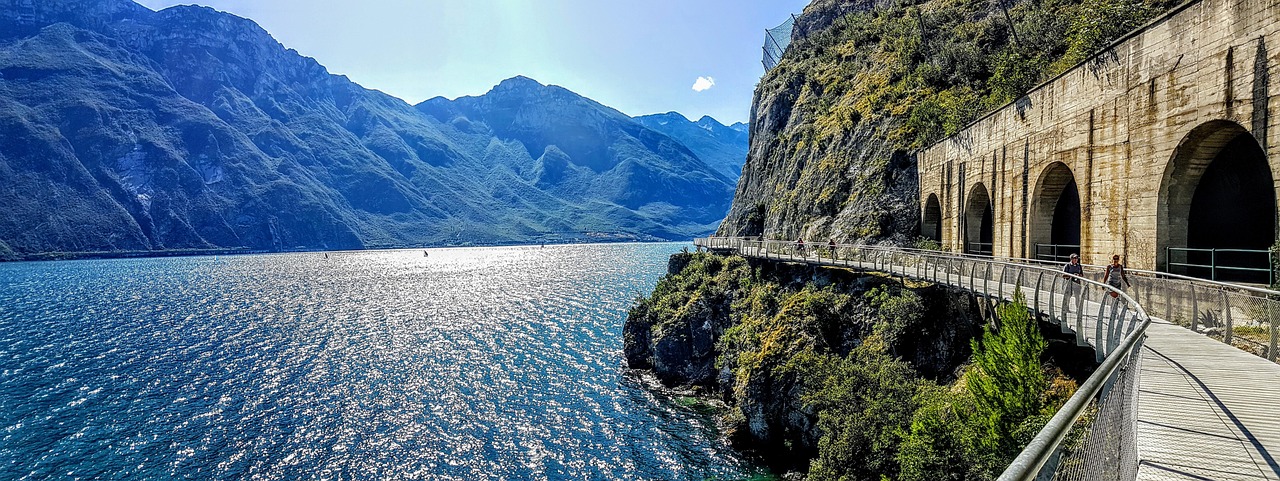 Ciclista su un percorso panoramico in Italia, circondato da paesaggi naturali spettacolari.