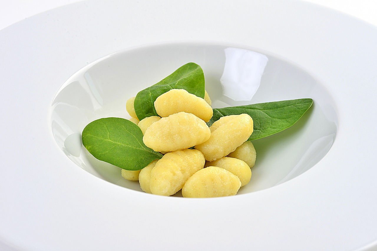 Gnocchi di patate leggeri e soffici serviti su un piatto elegante con salsa di pomodoro.