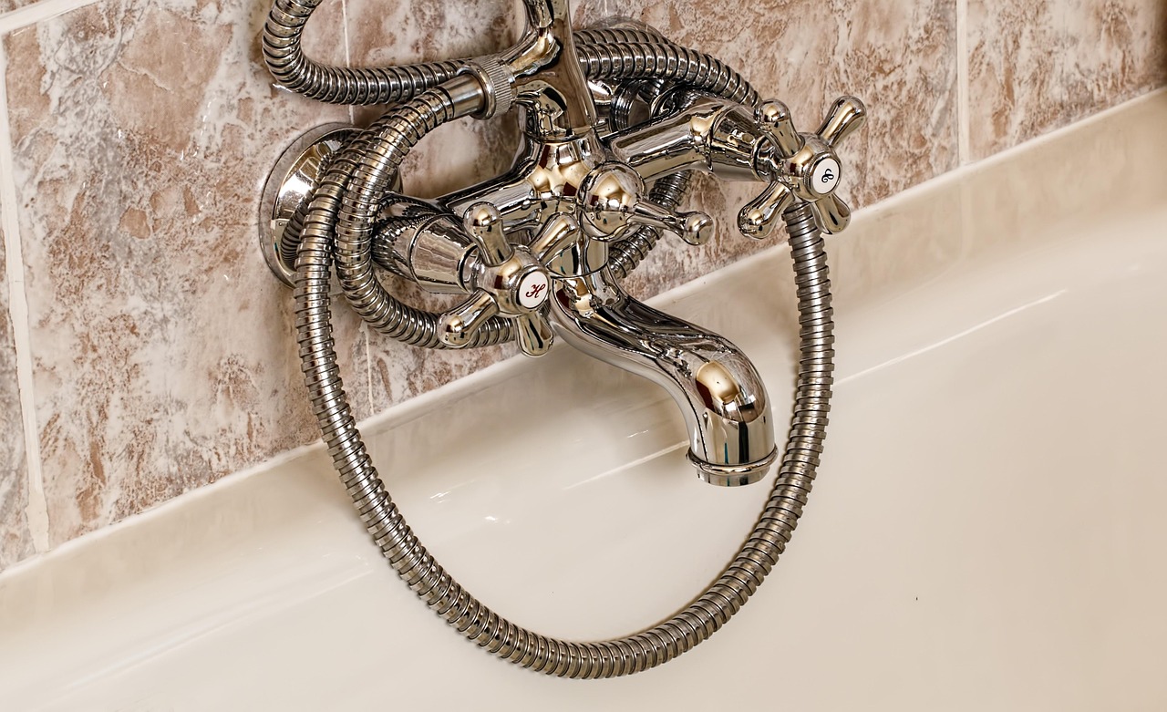 Immagine di un flacone di aceto bianco e un panno per pulire il calcare nel bagno.