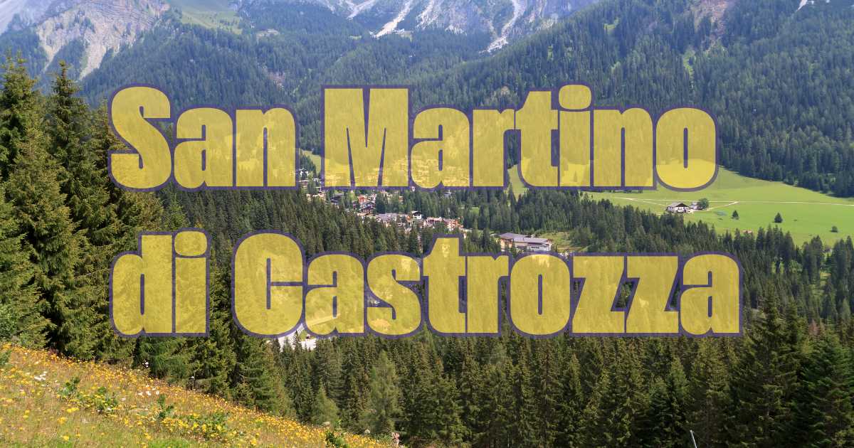 Panorama di San Martino di Castrozza in primavera, con prati verdi e montagne maestose.