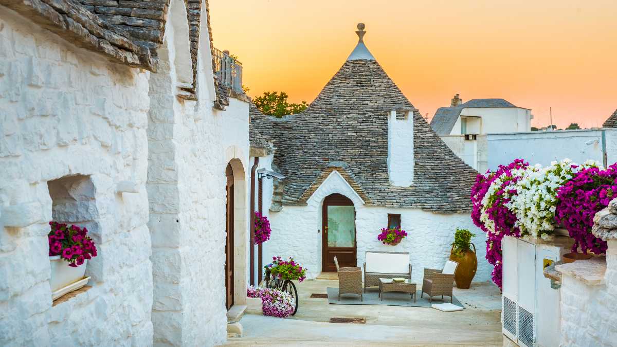 Trullo tradizionale pugliese immerso nella campagna italiana, simbolo di un alloggio tipico.