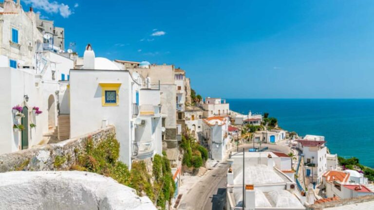 Borgo siciliano che ricorda i villaggi delle Cicladi: bianco, blu e arroccato sul mare