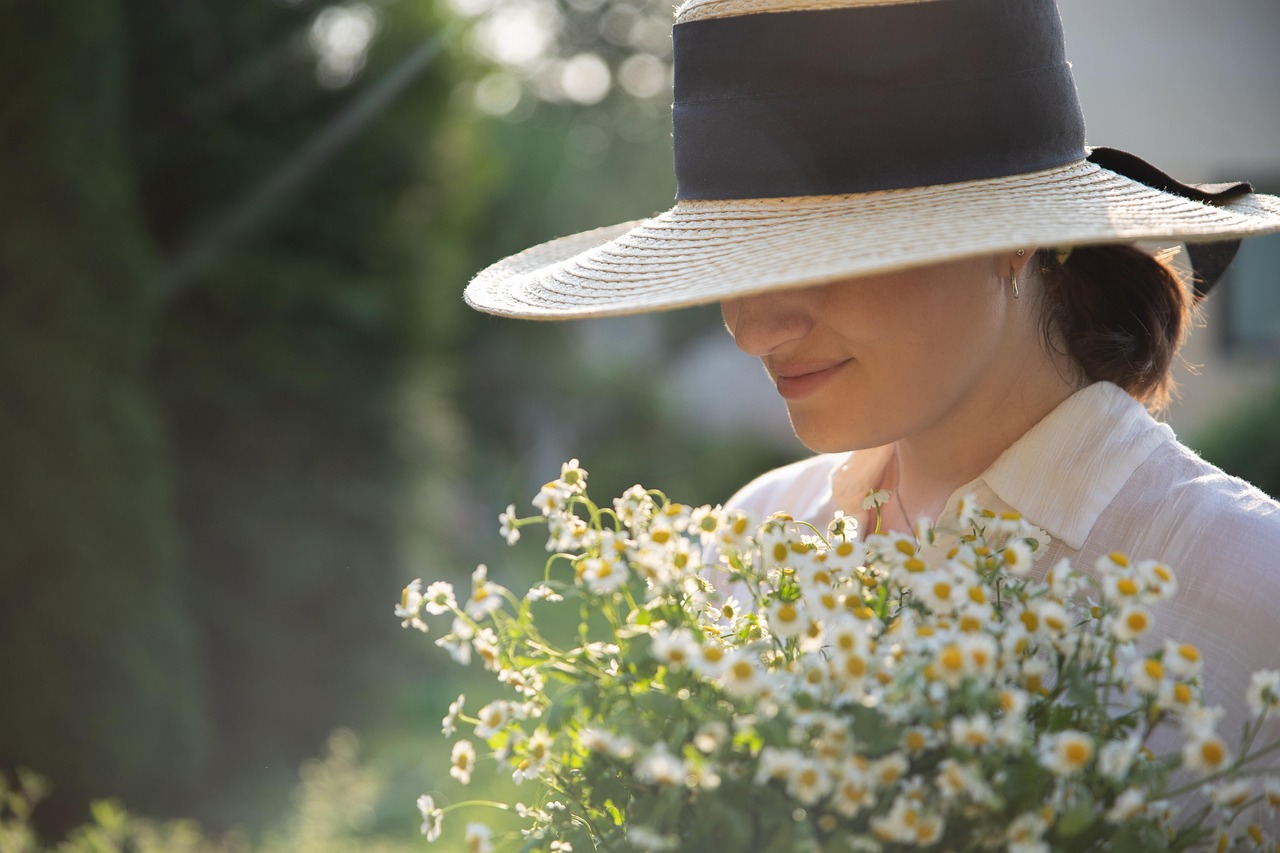 Checklist di luglio con immagine di attrezzi da giardinaggio e piante in un giardino curato.